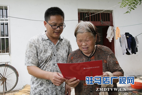 媽媽拿著兒子大紅色的大學(xué)錄取通知書(shū)，心里很美。.jpg
